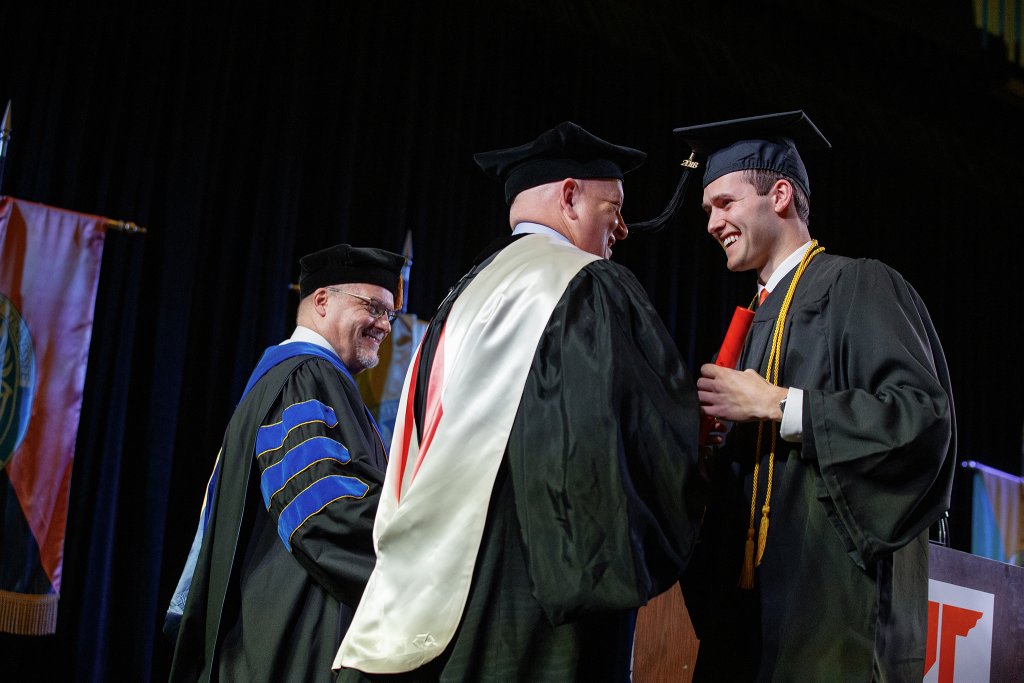 Jordan Long (right), of Martin, accepts his diploma from Chancellor Keith Carver (center). Dr. Philip Acree Cavalier, university provost, stands nearby. 