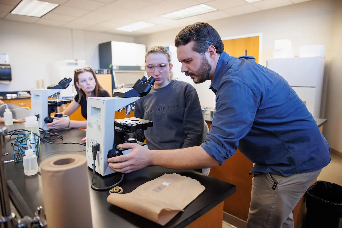 An instructor and students examining equipment in a UT Martin biology lab.