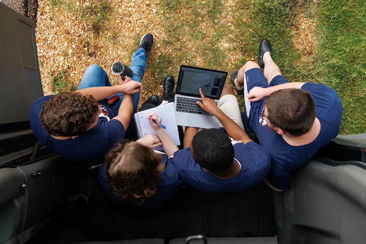 UT Martin meteorology students using laptops while working outdoors.