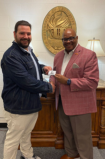 Andrew Larkings receiving a gift card from Chancellor Freeman